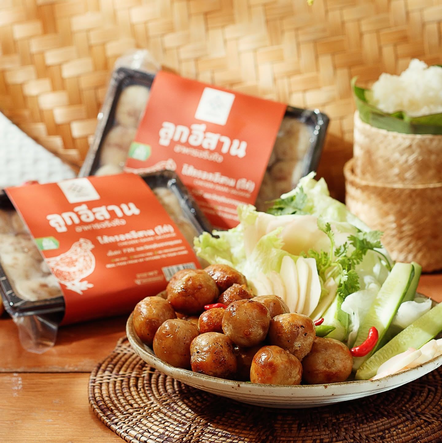 Look Isaan pork and chicken Isaan sausages served with sticky rice, cucumber, and fresh herbs